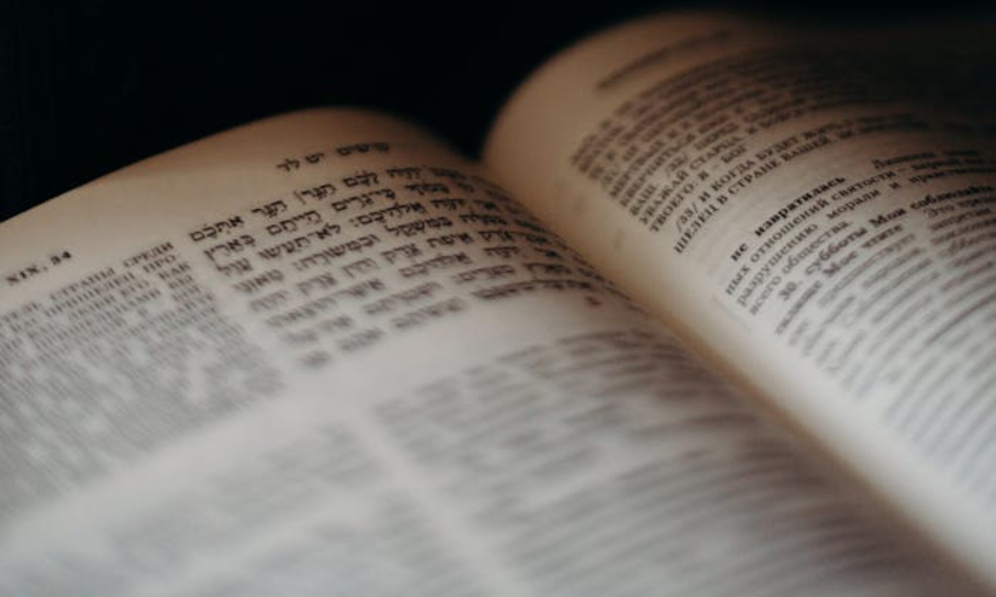 Close-up of an open Hebrew book with soft, dramatic lighting, emphasizing Jewish traditions.